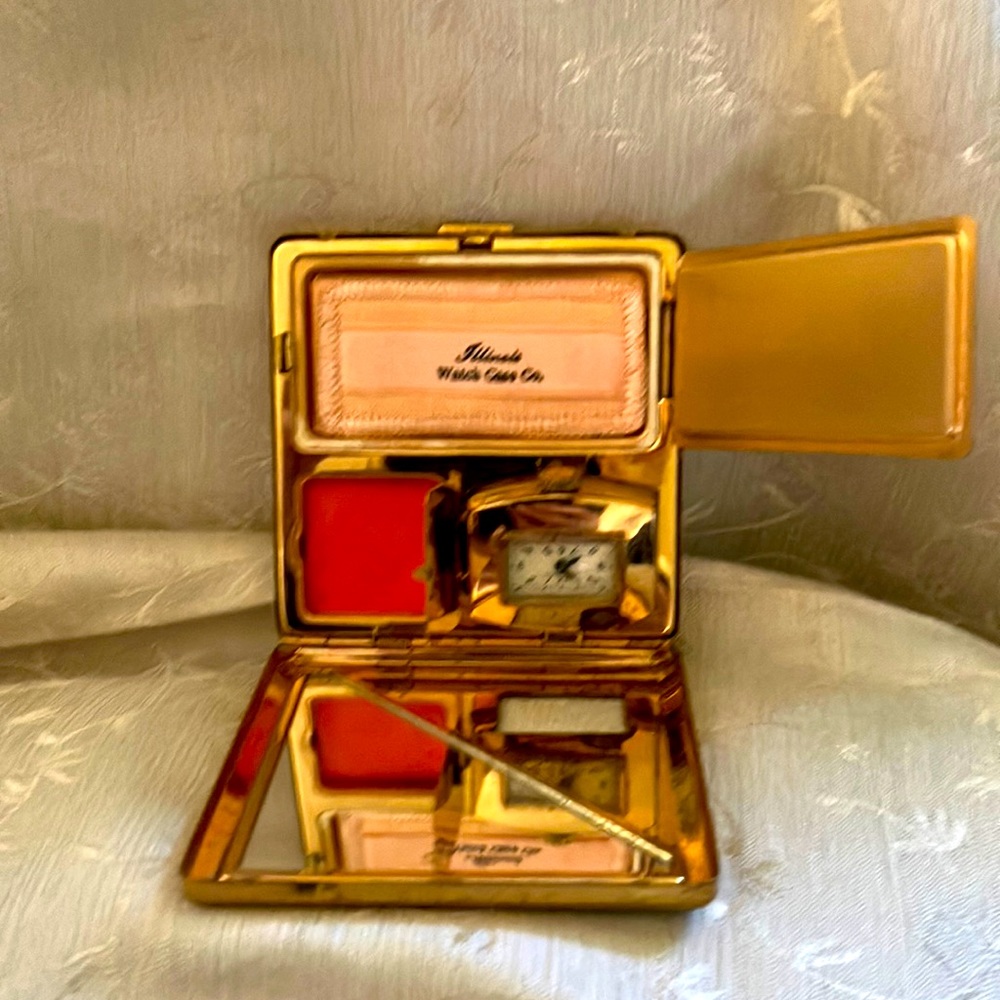 Compact black with clock. Illinois watch case co. Has spot for powder.Has rouge